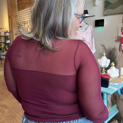The Sheer Aura Sweetheart top in burgundy, showing the back view with mesh detail and sheer sleeve detail on model at Gypsy Spirit Boutique.