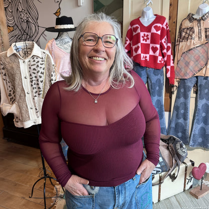 The Sheer Aura Sweetheart top in burgundy, showing the intricate sweetheart neckline with mesh sheer detailing and sheer sleeve detail on model at Gypsy Spirit Boutique.